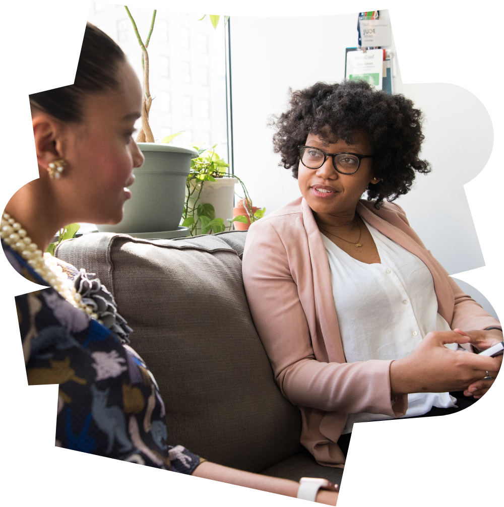 Two women sitting on a sofa, talking